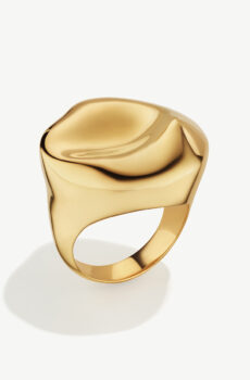 An abstractly shaped gold ring with the bulk of the ring being at the top.