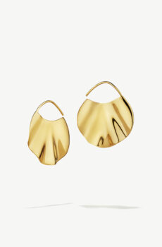 Two gold wavy earrings floating on a white background.