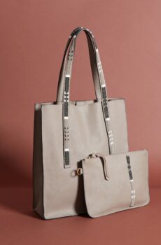 A muted beige toat back with a long strap and a smaller clutch-style back of the same color in front of it