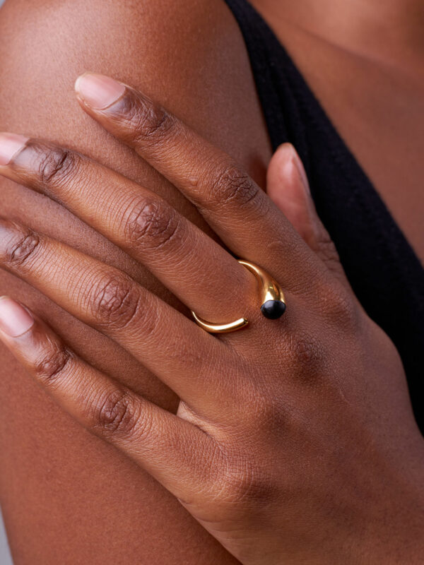 person wearing 24K gold-plated recycled brass ring with recycled horn in black