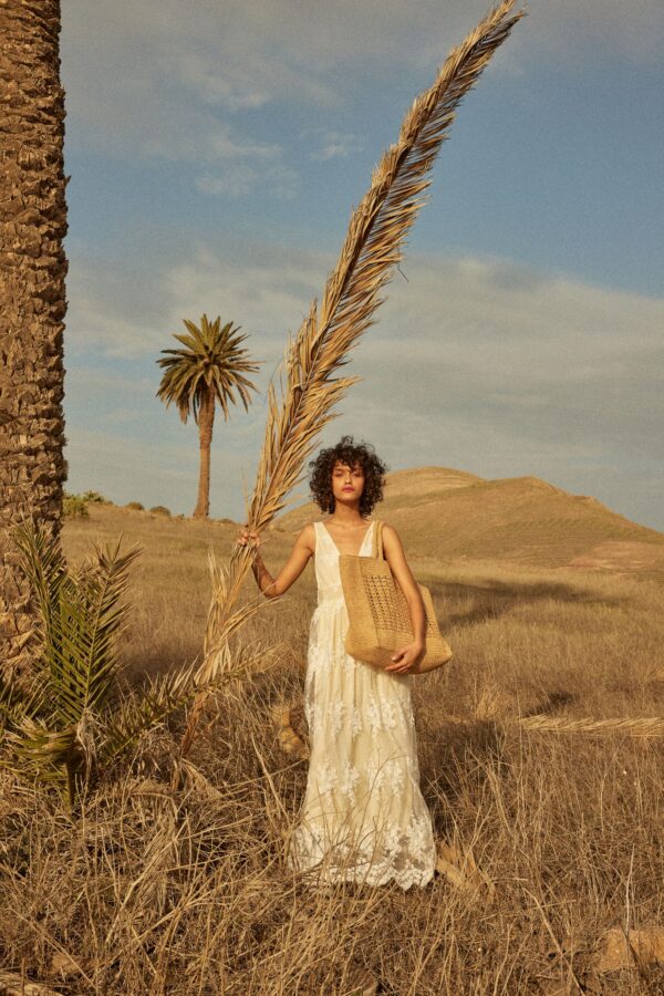 person carrying raffia tote