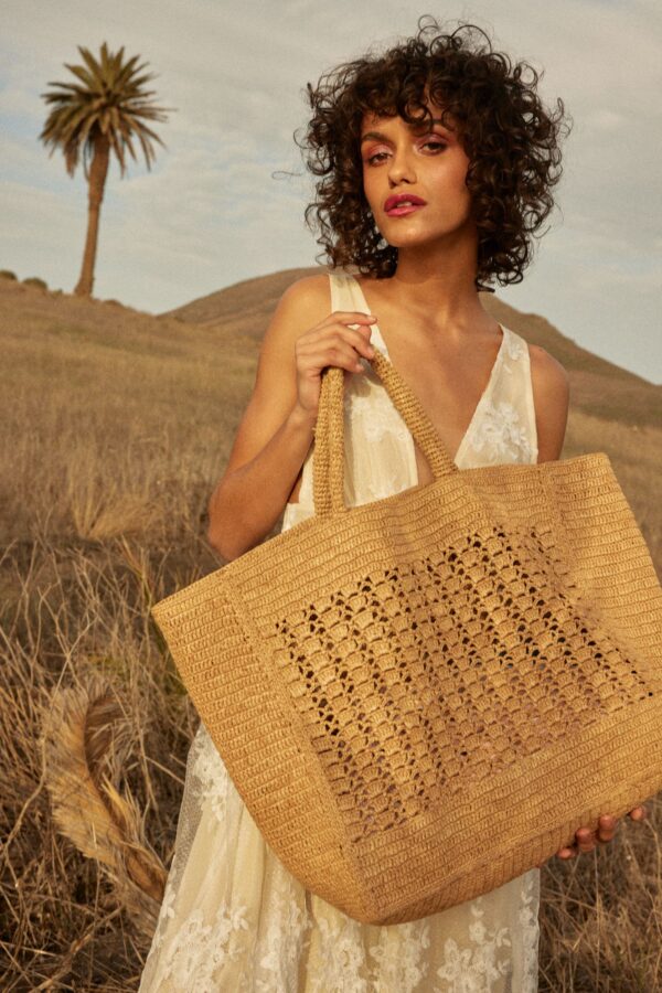 person holding raffia tote