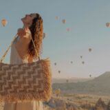person carrying raffia bag