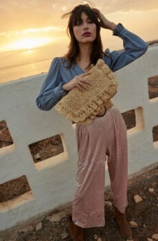 person holding raffia bag