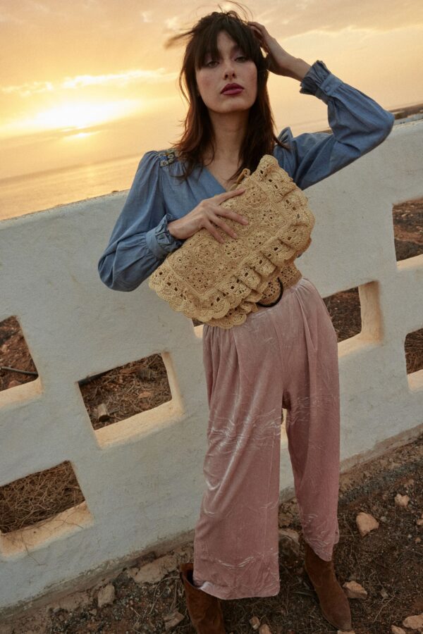 person holding raffia bag