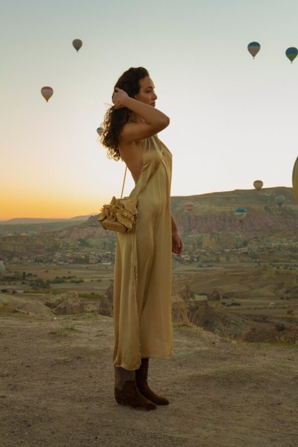 person carrying raffia bag