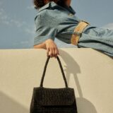 person holding raffia bag
