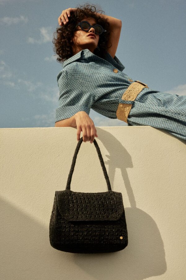 person holding raffia bag