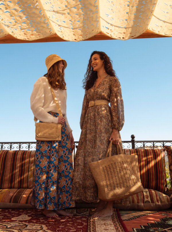 two people carrying raffia bag